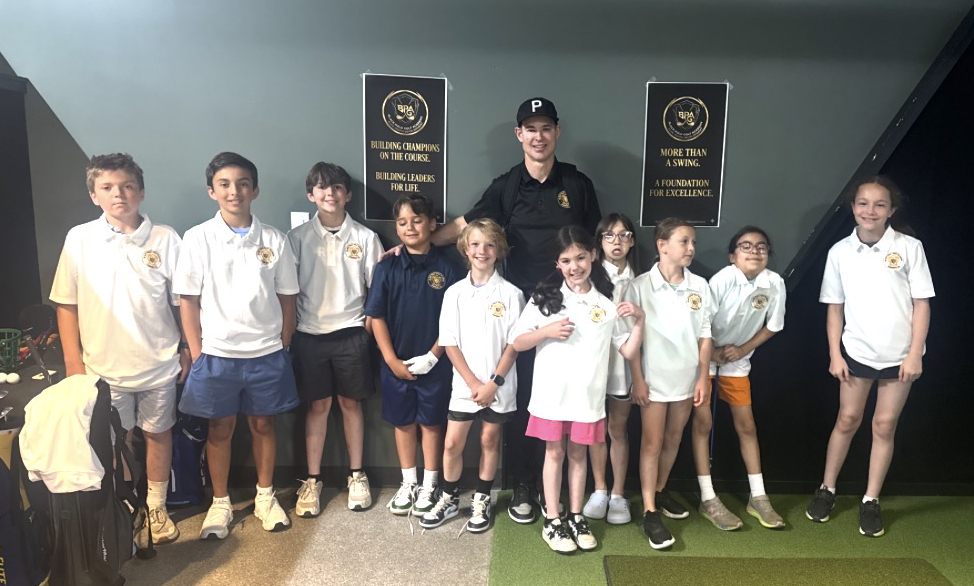 Black Polo Golf academy students and coach standing together indoors